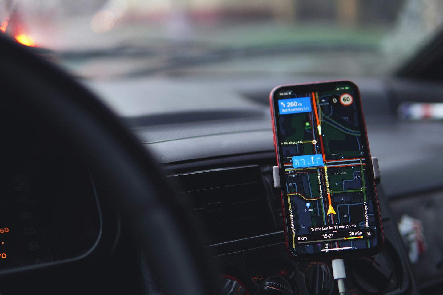 Smartphone mounted on car dashboard showing navigation app.